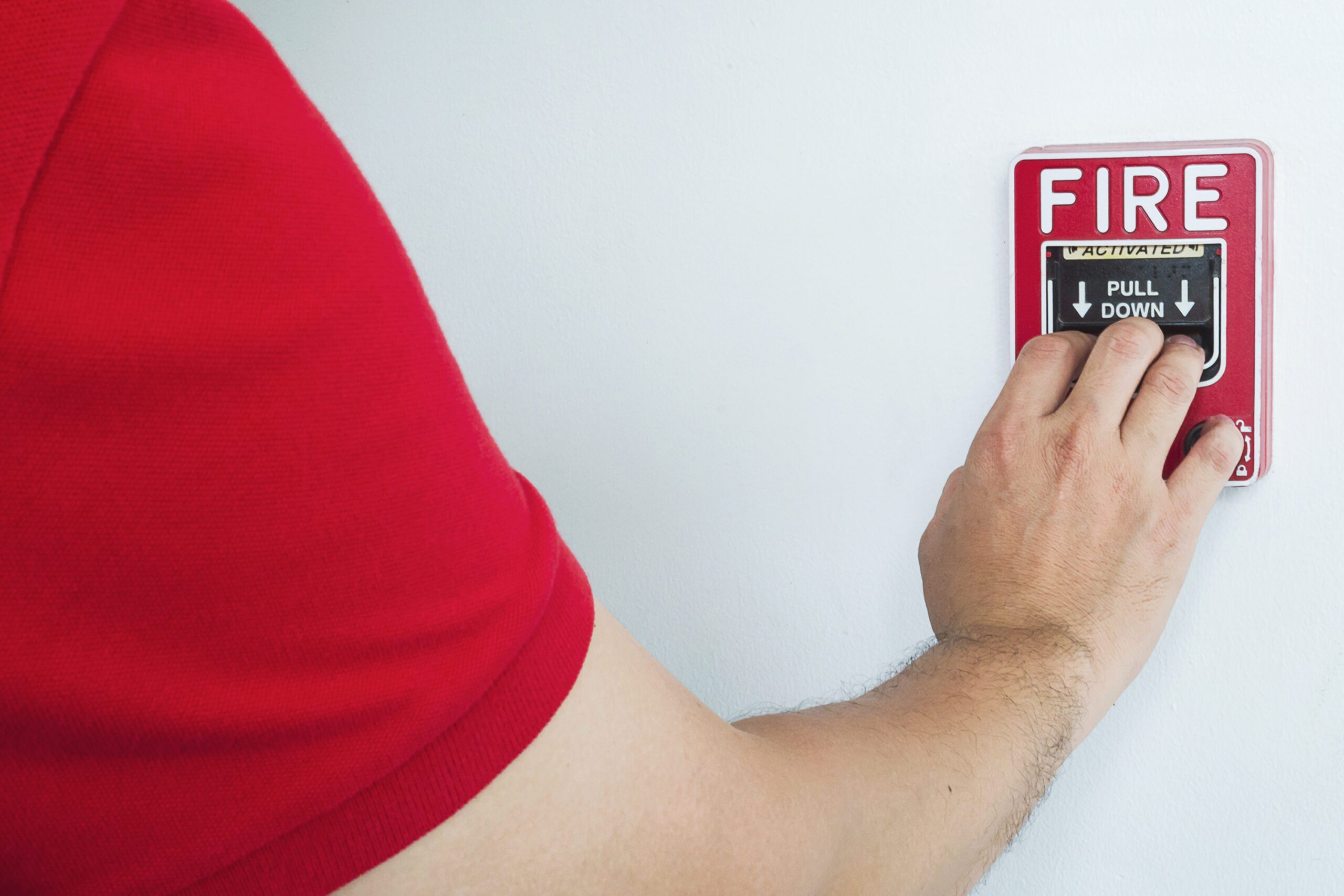 Smoke detector installation man is reaching his hand push fire alarm hand station scaled